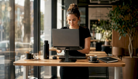 Im Homeoffice nutzt eine Frau einen ergonomischen Laptop-Ständer, um komfortabel zu arbeiten.